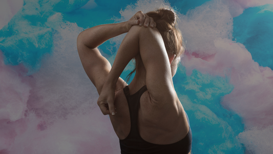 A person in a black tank top stretches with their arms above their head